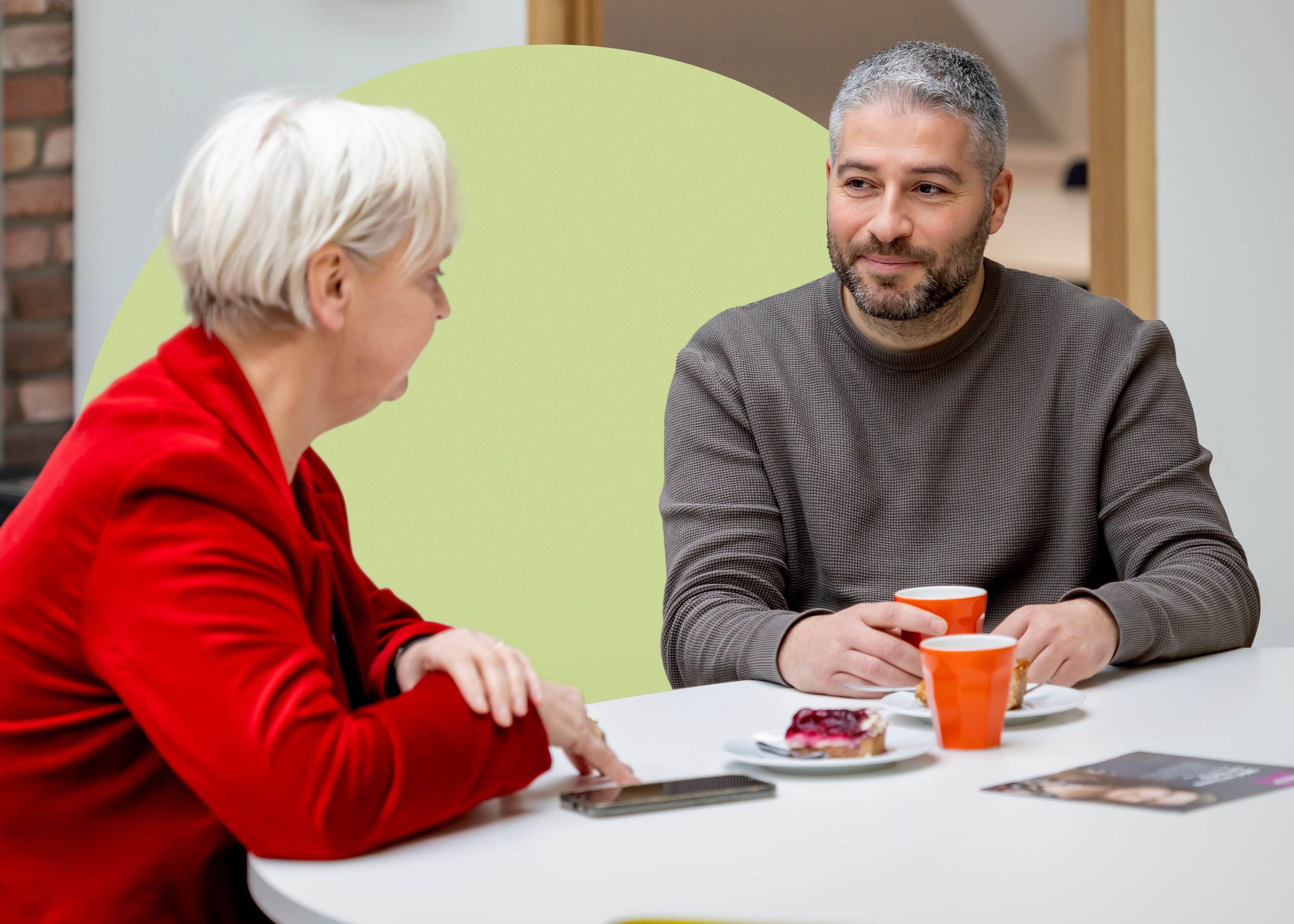 Sukru in gesprek met collega op kantoor
