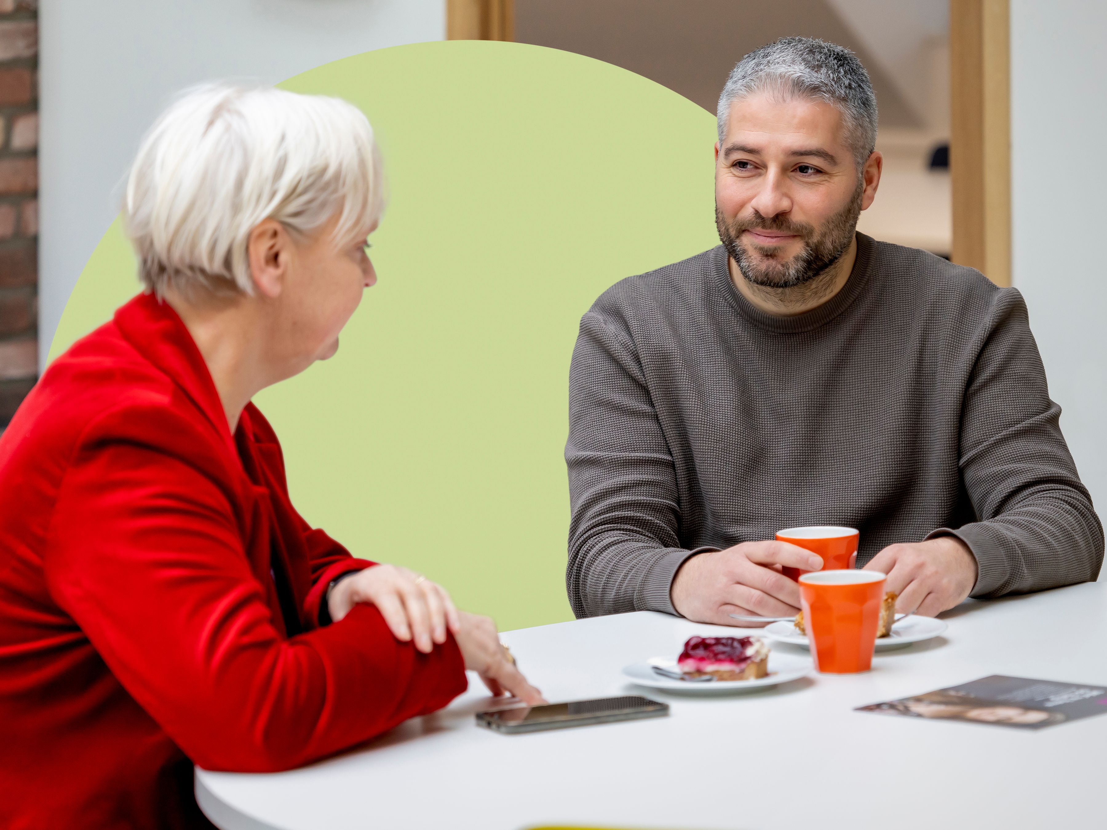 Sukru in gesprek met collega op kantoor