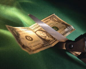Cutting a One Dollar Bill with a Scissors | Copyright: © Corbis