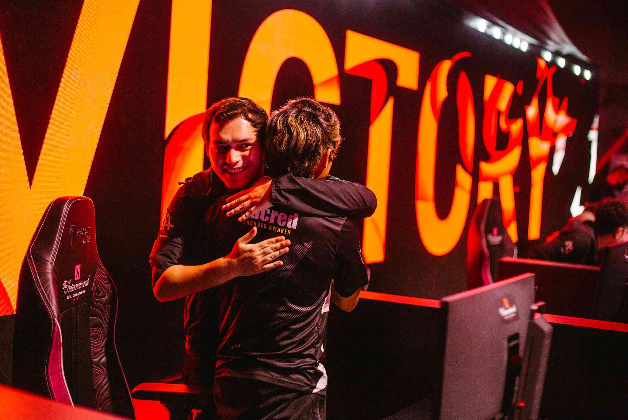 Members of Thunder Awaken embrace each other following their upper bracket first round series win over Evil Geniuses in TI11