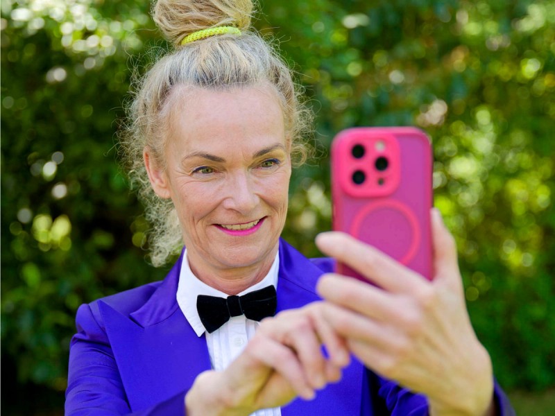 Benimm-Expertin Nicole Schlepphorst blickt auf ihr Smartphone. Das Bild steht für moderne Umgangsformen im digitalen Alltag.