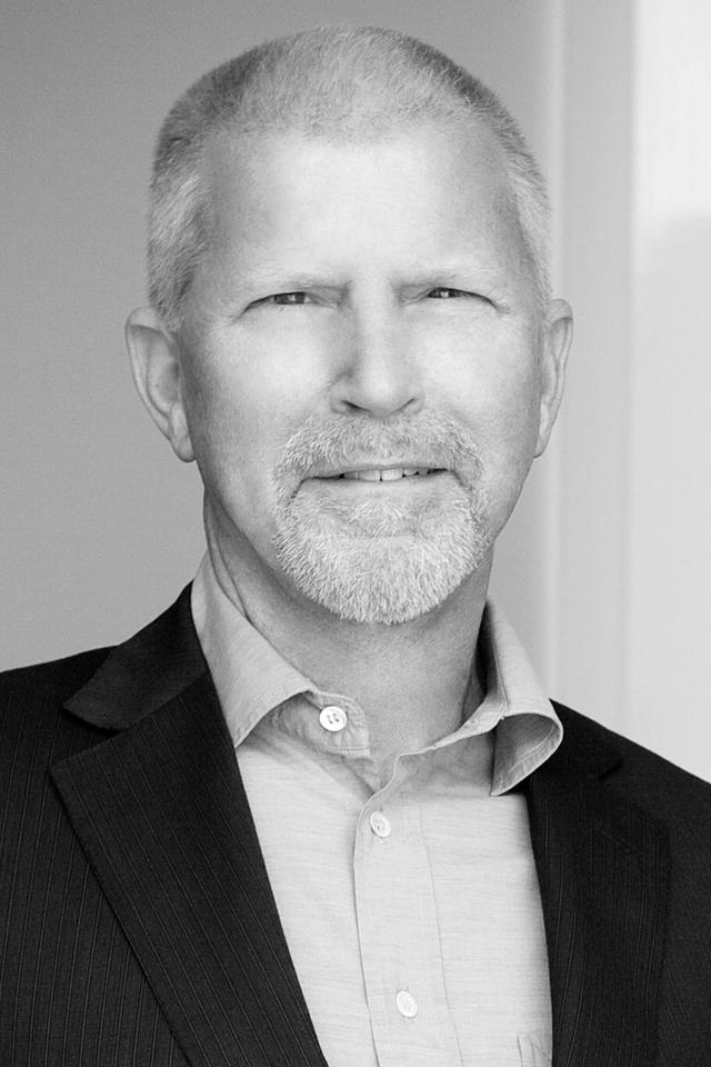 man smiling with a suit and dress shirt in a black and white photo