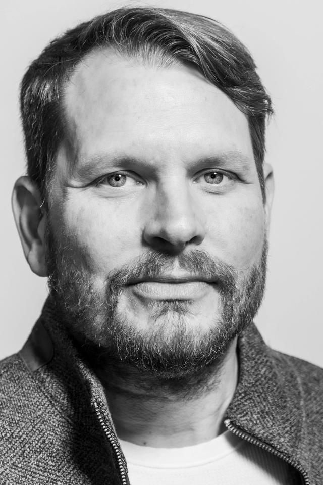 Black and white photograph of Andrew Gibson, looking into the camera lens