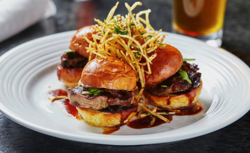 Three Pinstripes shareable plates of tenderloin sliders with truffled potato strings, shallot mayo, arugula, and bordelaise.