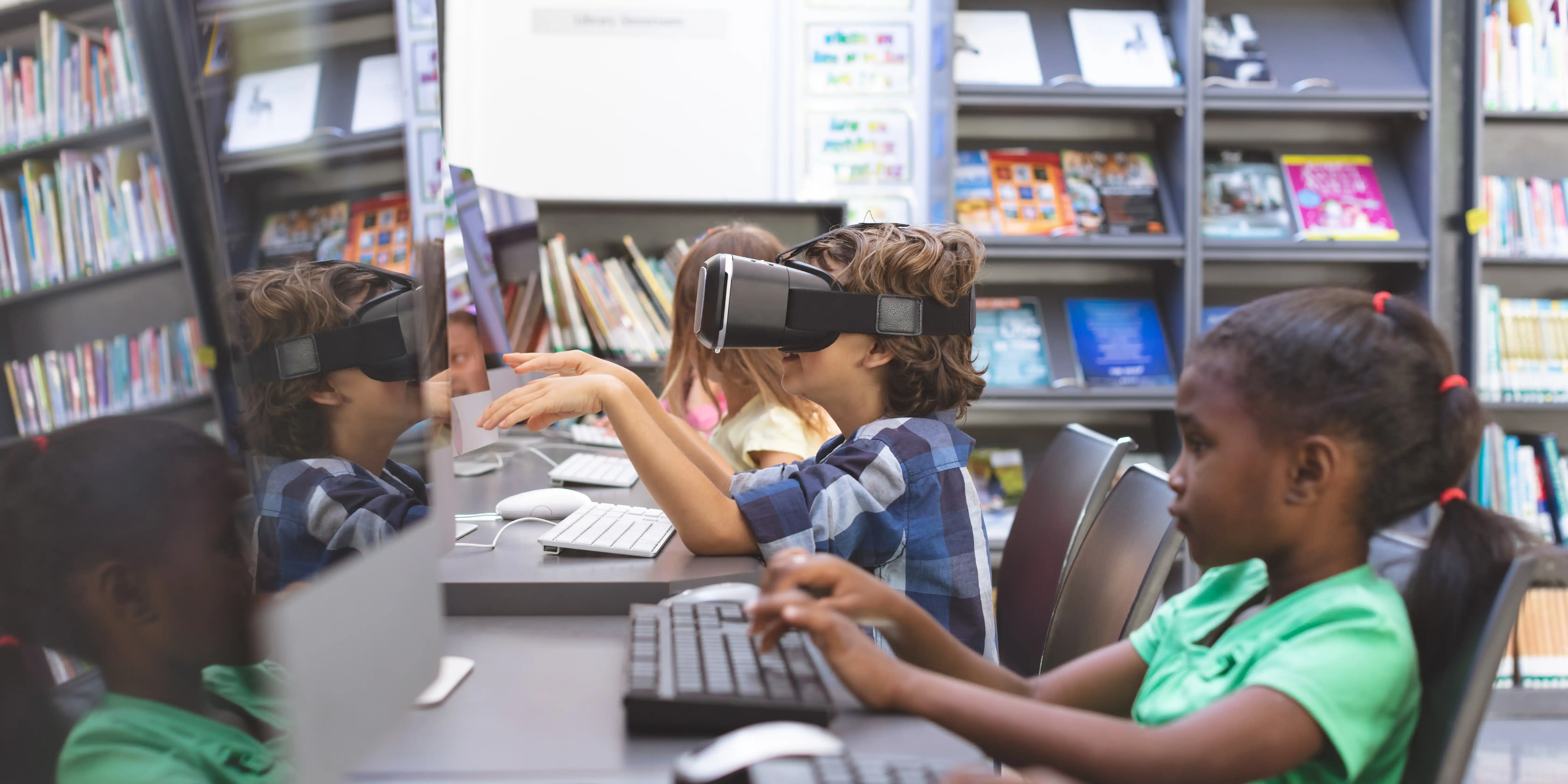 kids sitting at a desk using VR set