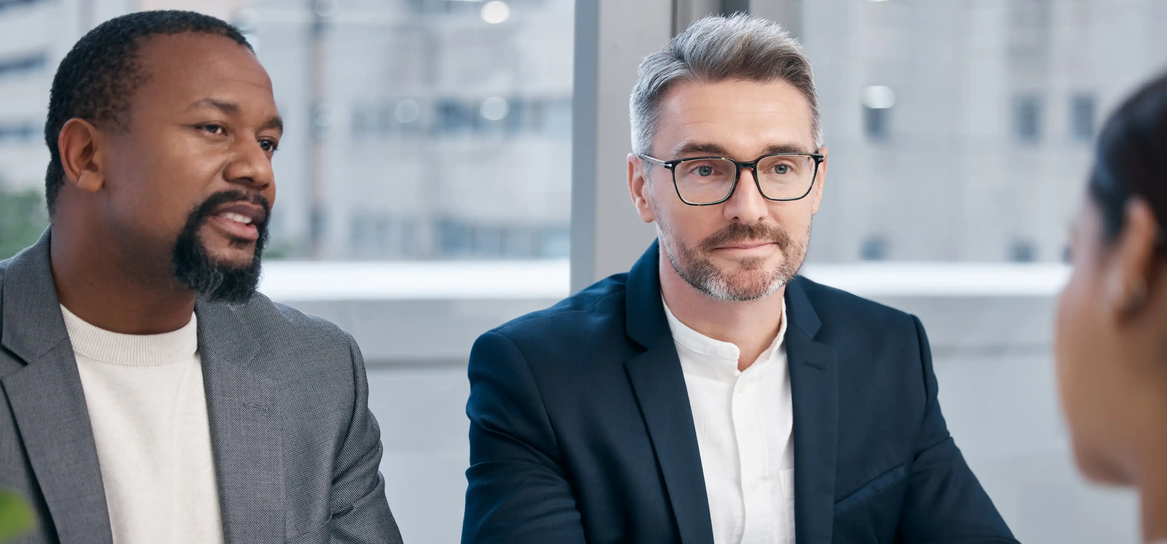 two business professionals in suits speaking with client