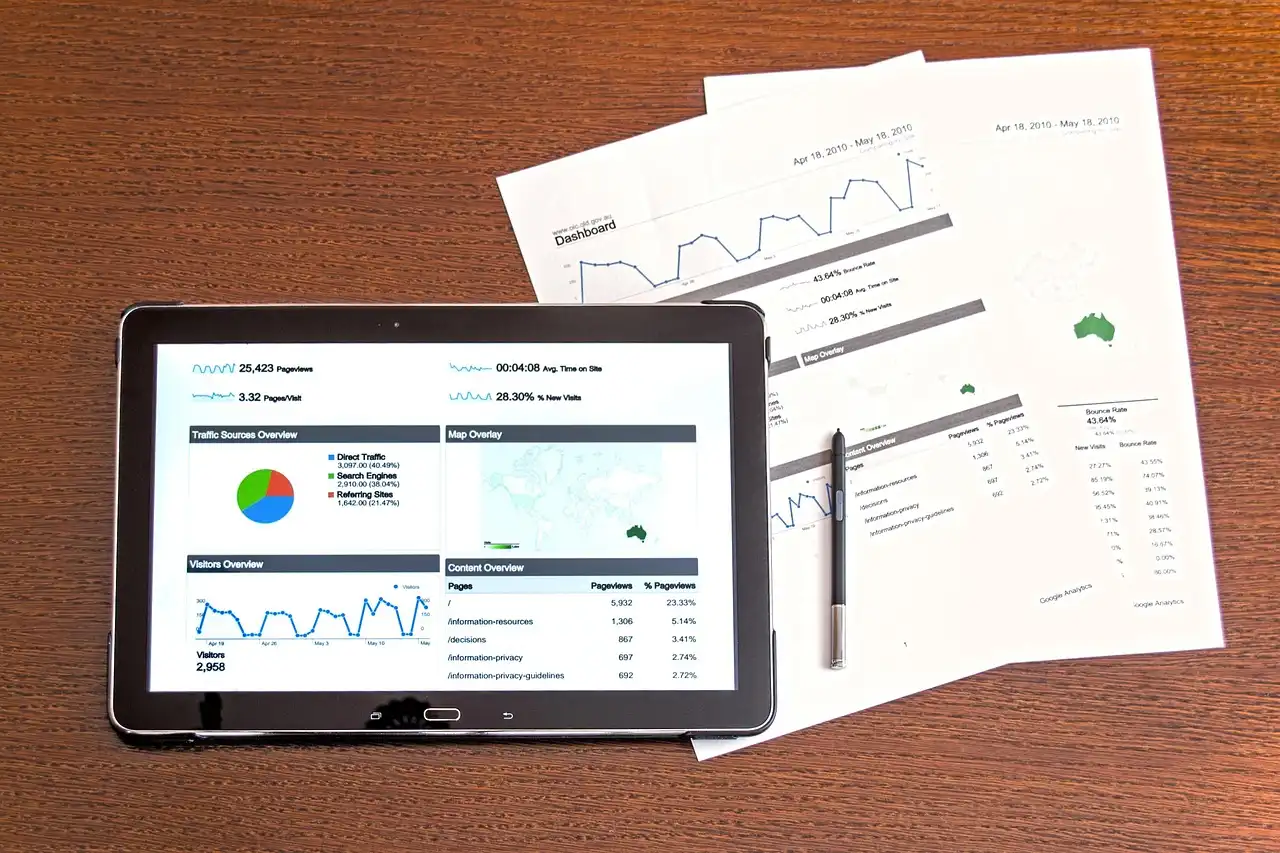 Analytics charts on a tablet beside printed reports