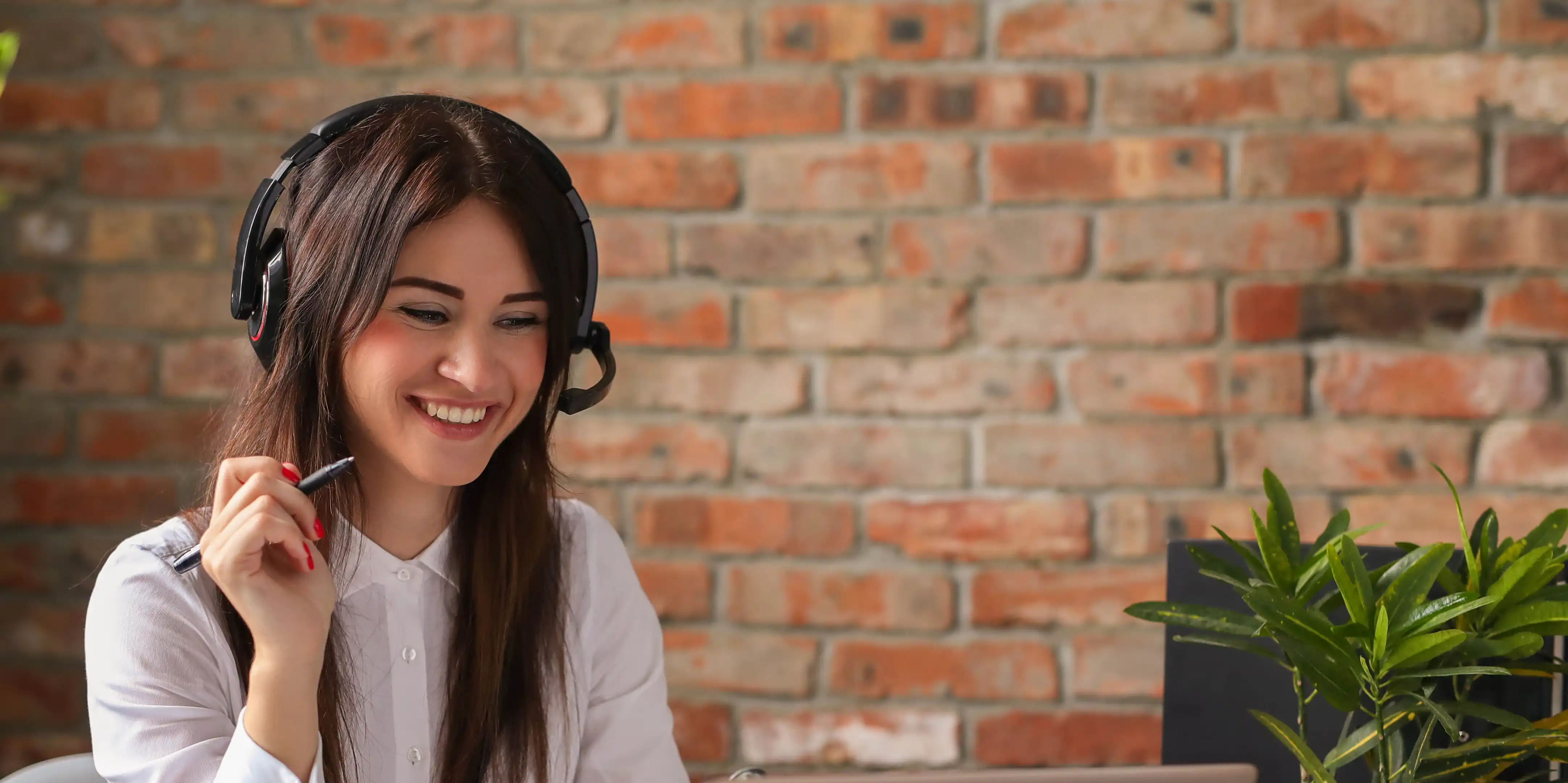 Woman with a headset on smiling at computer