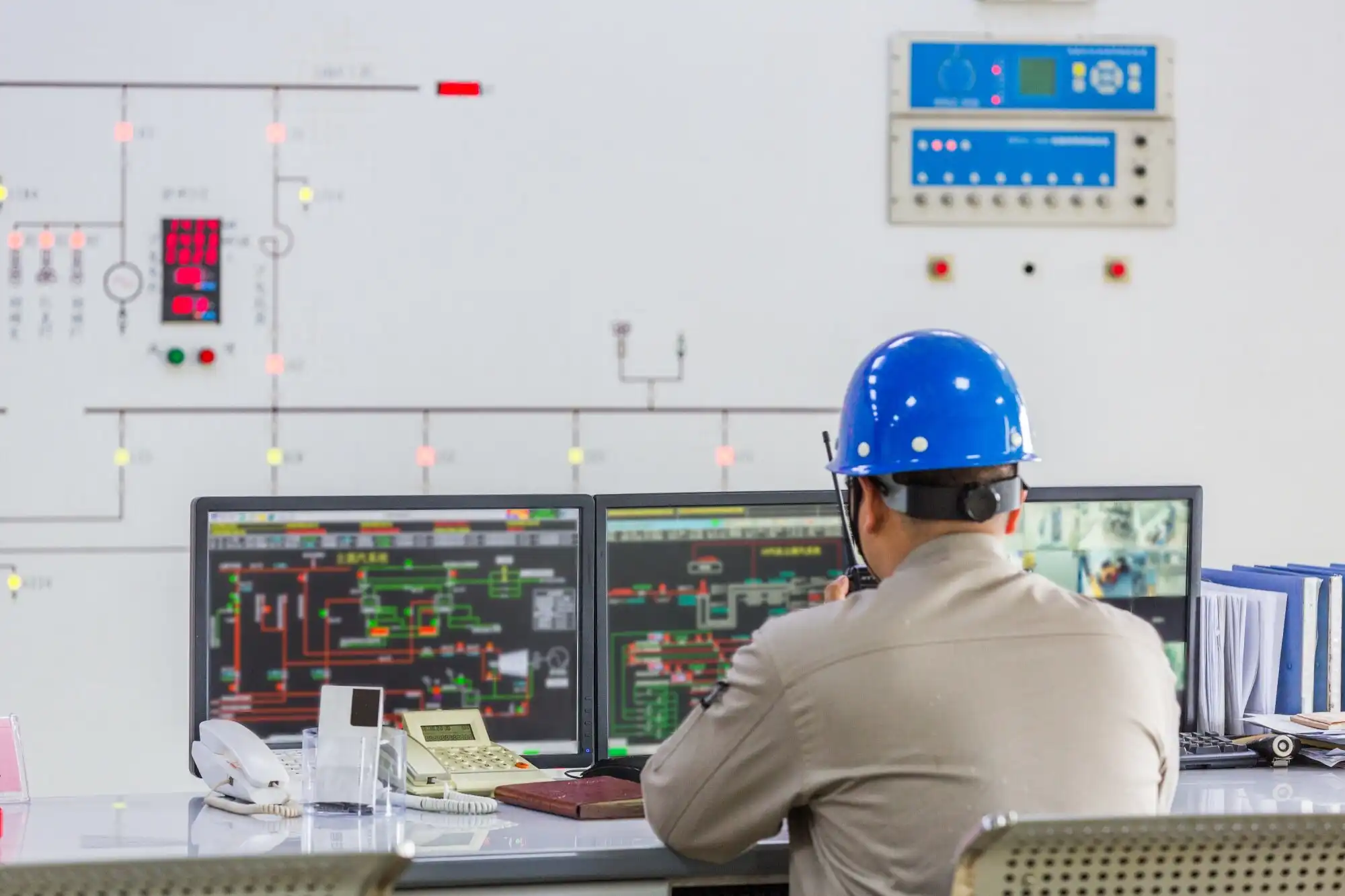 worker wearing hard hat in control room