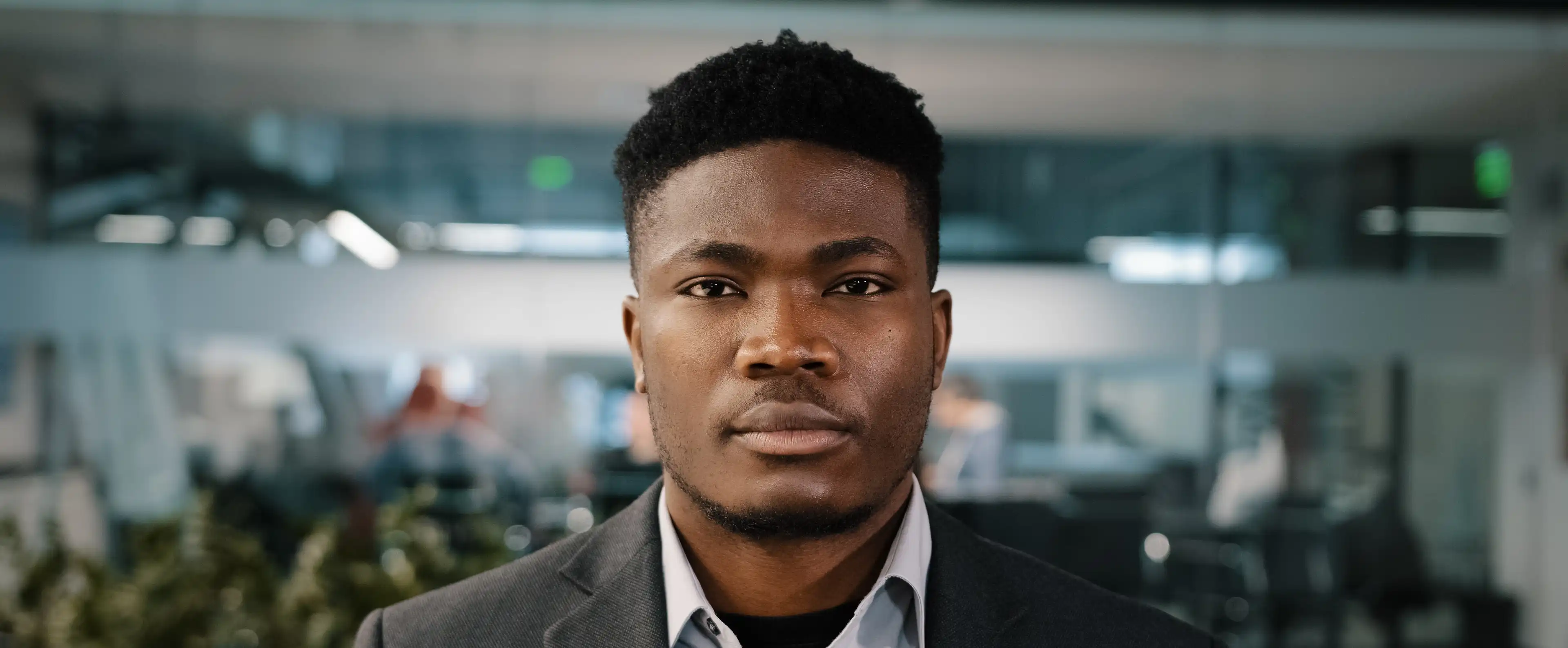 Professional man dressed in dark grey suit with light blue shirt