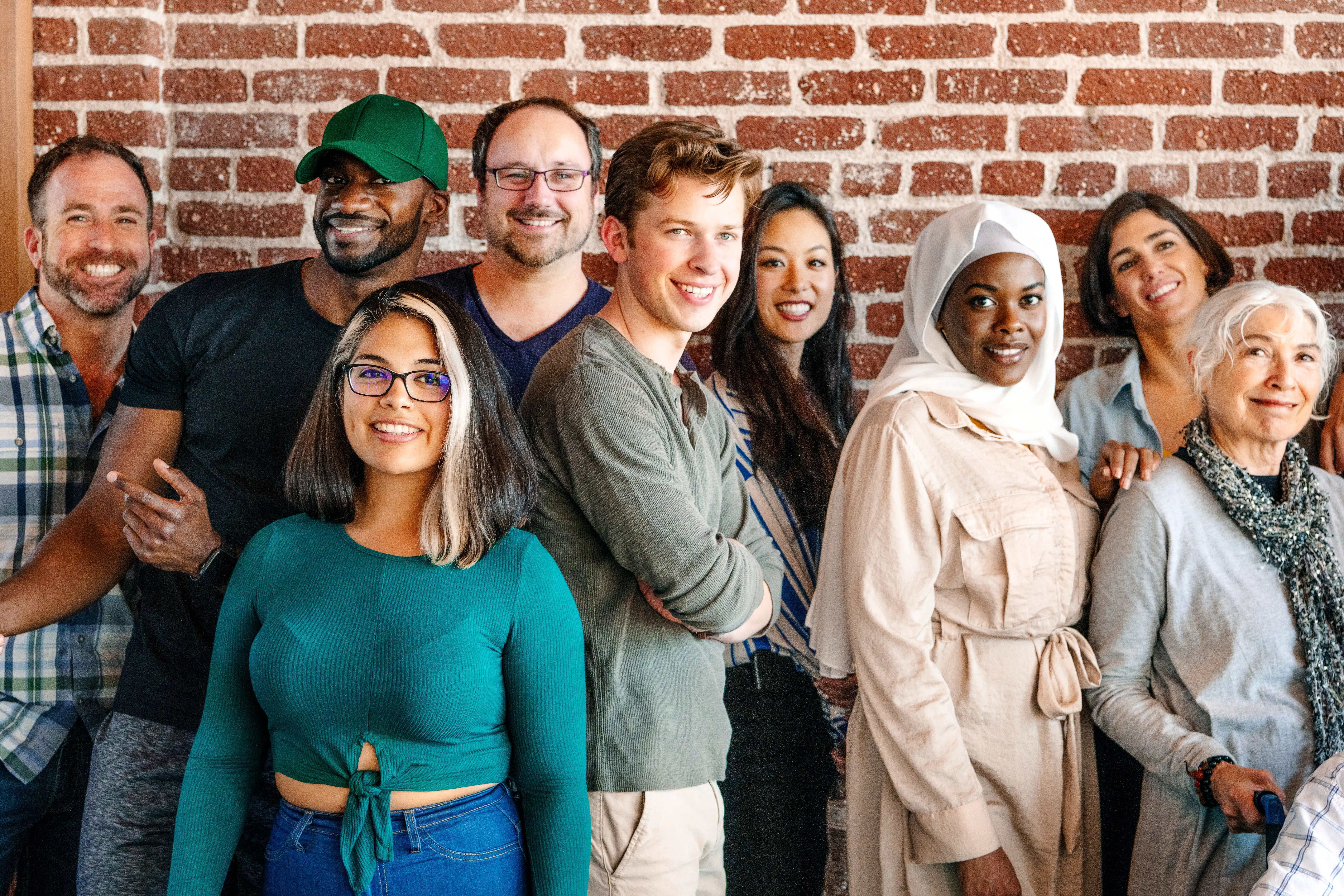 diverse multiracial group of people posing for photo in brightly lit environment