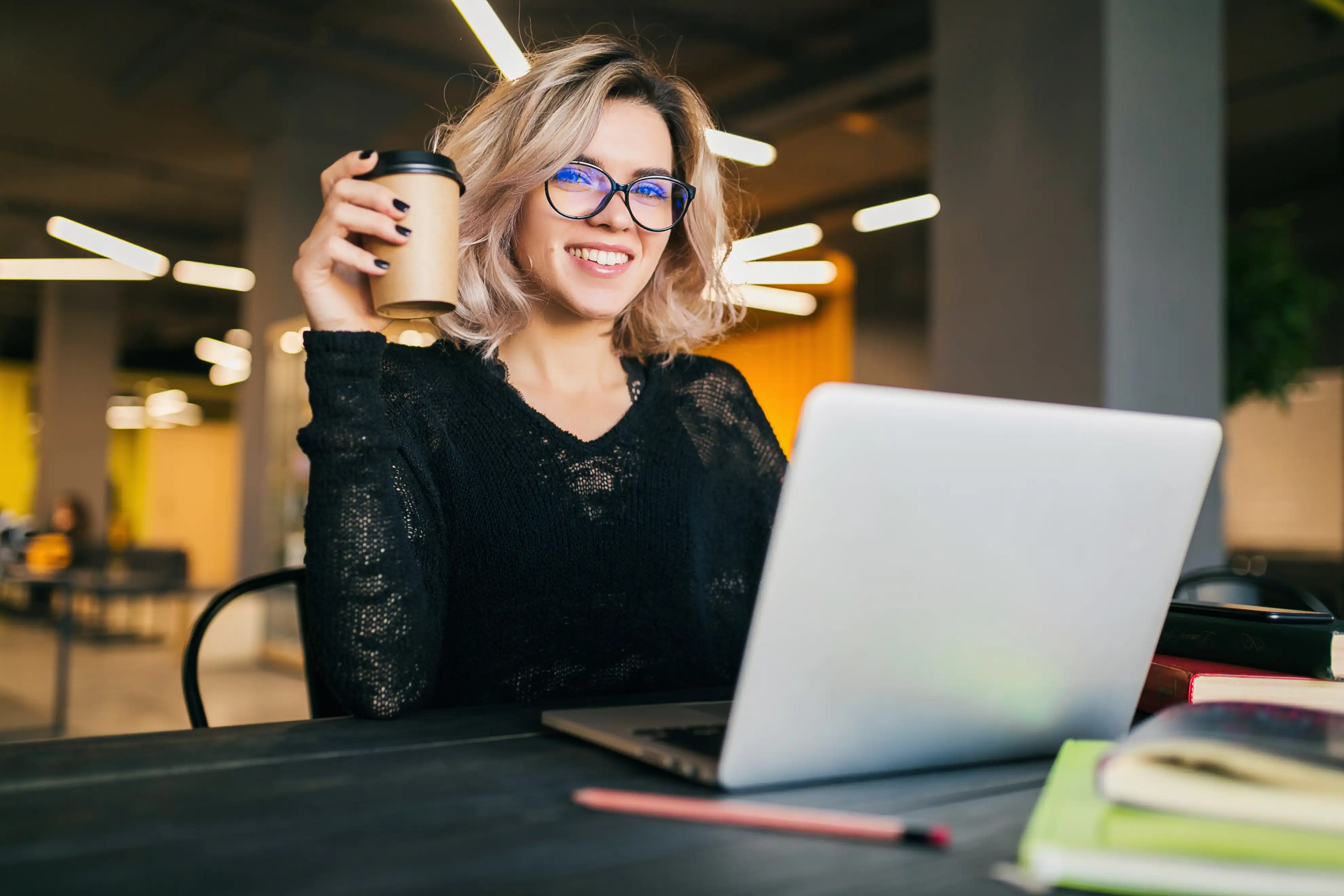 woman holding a coffee while at work