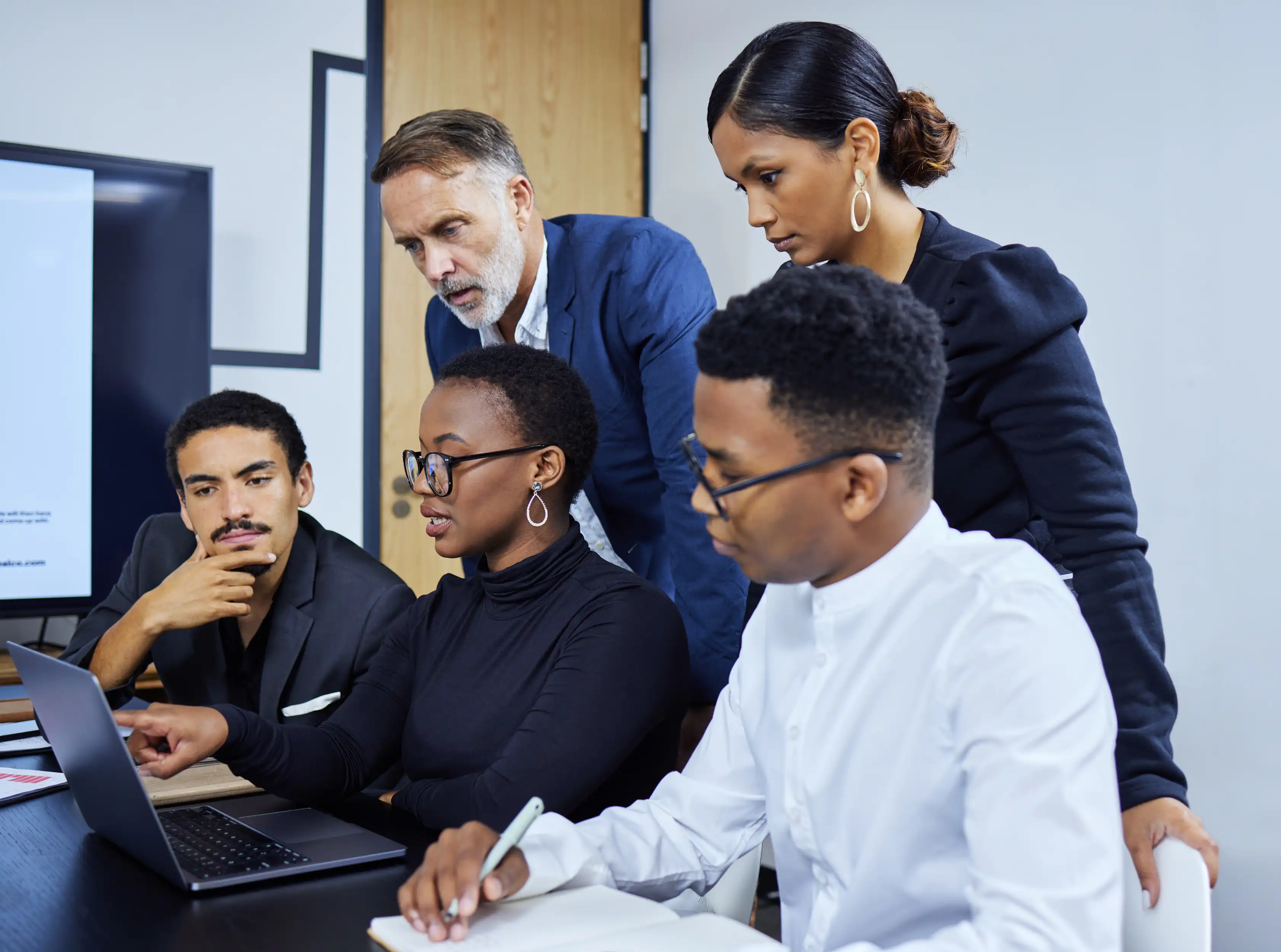 professional work colleagues viewing a laptop screen together