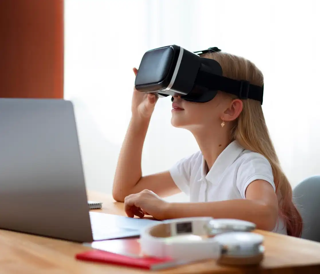 young student wearing vr headset in front of laptop