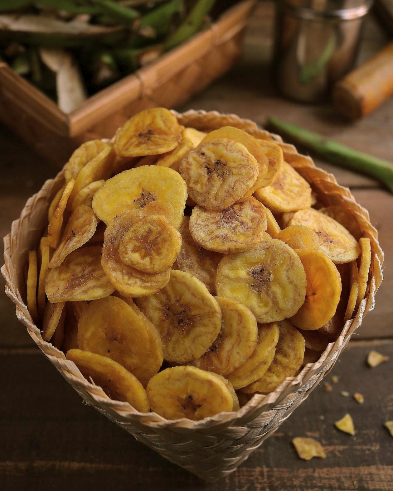 Golden banana chips in a basket — comparing the nutrition of Kerala banana chips versus potato chips