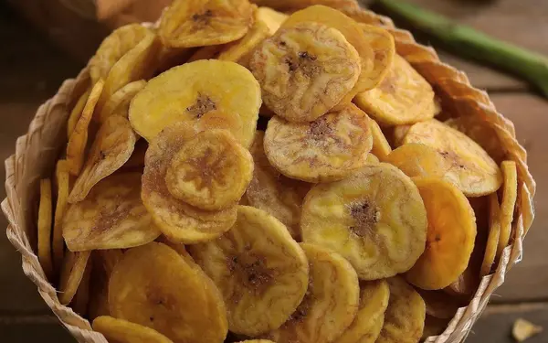 Golden banana chips in a basket — comparing the nutrition of Kerala banana chips versus potato chips
