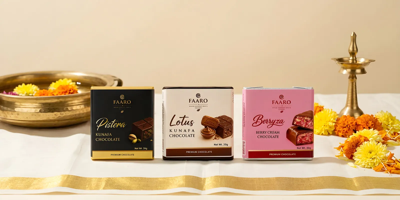Three Faaro chocolate packs on a gold-bordered kasavu cloth beside a brass uruli of flowers and a nilavilakku lamp for Onam