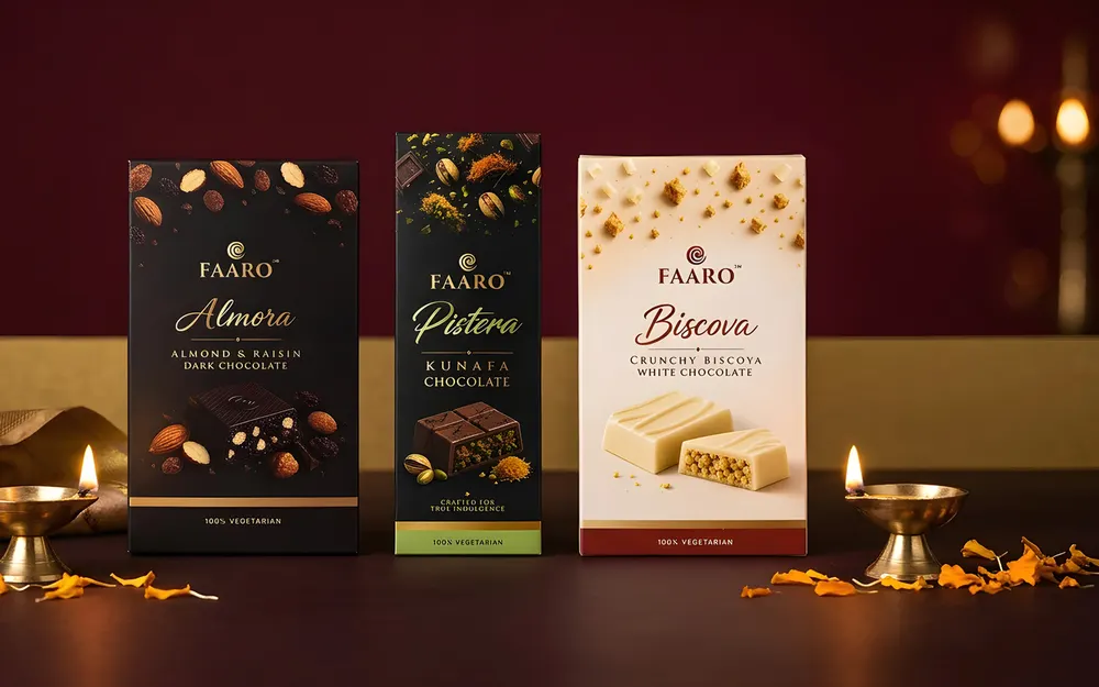 Three Faaro chocolate bars arranged for corporate Diwali gifting with brass diyas and marigold petals on a maroon and gold setting