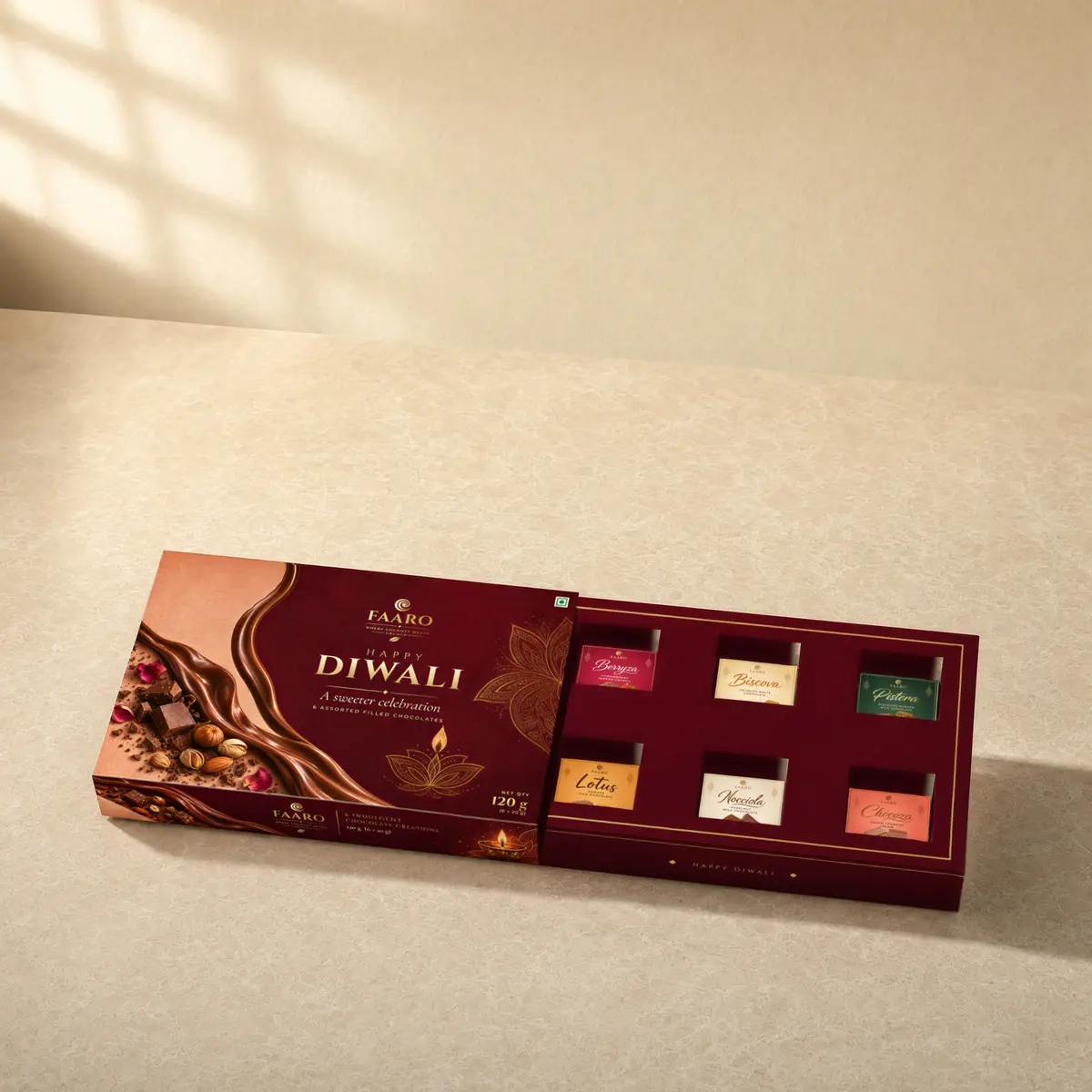 The FAARO Diwali gift box with its drawer pulled out, showing six filled chocolates each under a flavour sticker: Berryza, Biscova, Pistera, Lotus, Nocciola and Chocoza