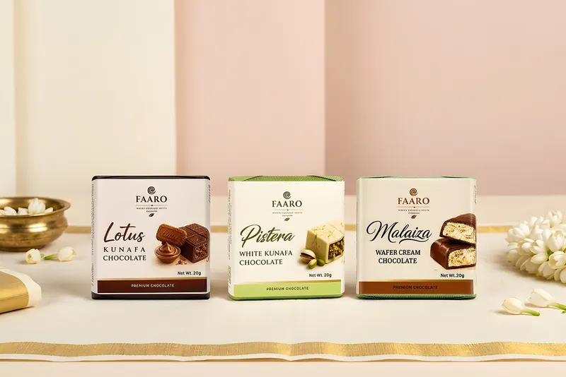Three Faaro chocolate packs arranged as South Indian wedding favours on a gold-bordered handloom cloth with jasmine