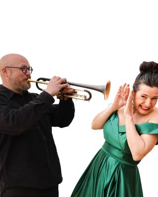 A trumpeter playing into a soprano’s ear