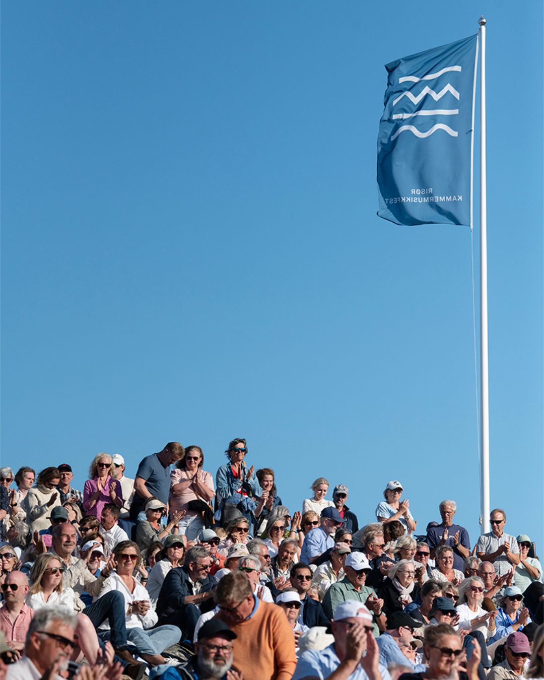 Et vaiende Risør kammermusikkfest-flagg med publikum