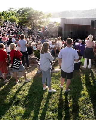 A packed Stangholmen with the audience beneath a glowing evening sky