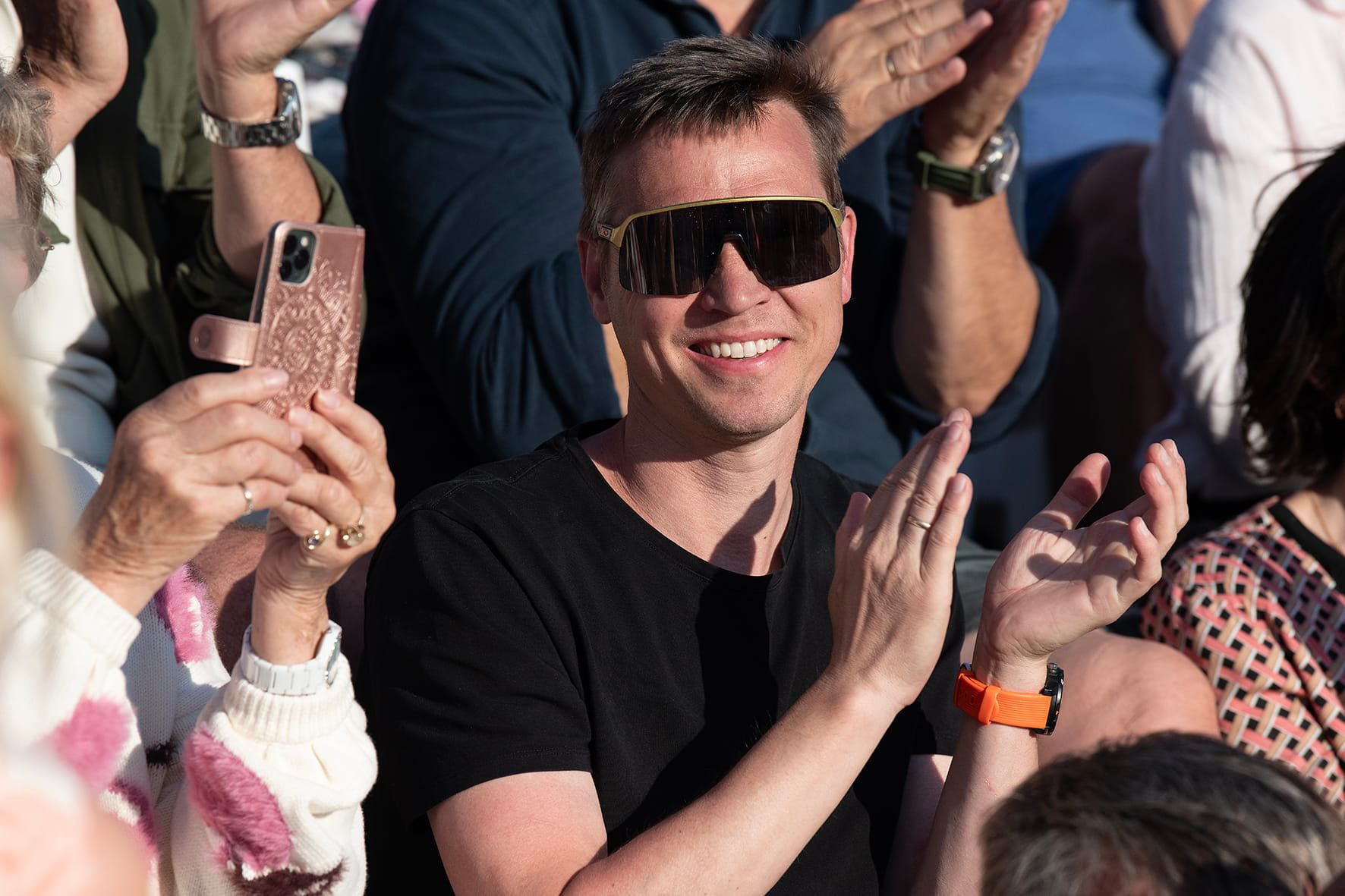 En strålende fornøyd mannlig publikummer med raske briller applauderer under konserten på Stangholmen.