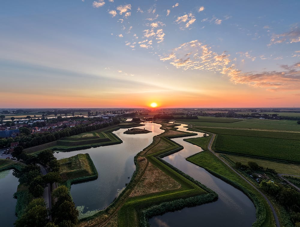 Aerial view of a star-shaped moat and lake at sunrise