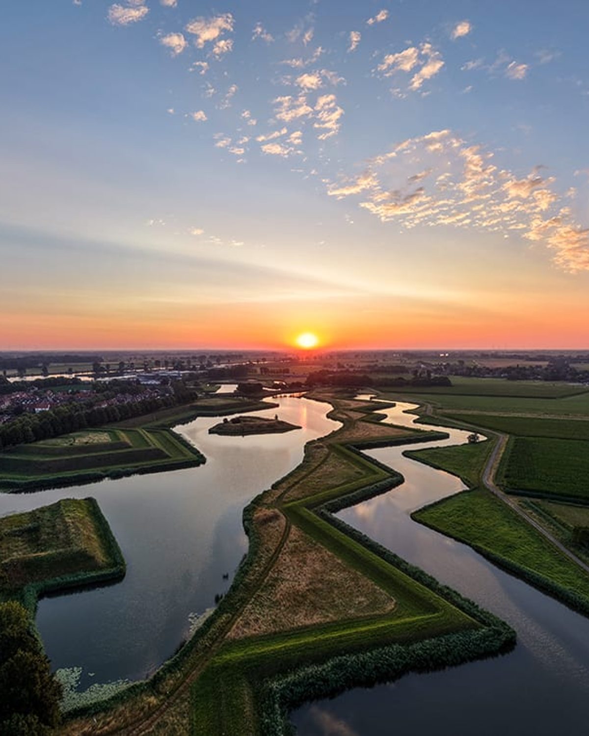 Aerial view of a star-shaped moat and lake at sunrise