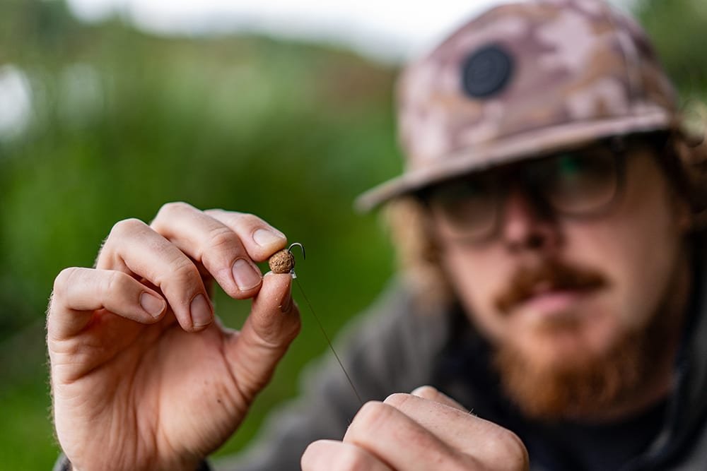 Joe holding up a baited hook, a wafter on a hair rig