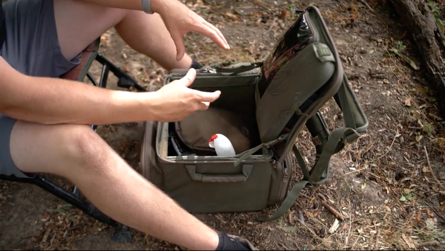 Padded shoulder straps and reinforced waterproof base of a carp fishing rucksack