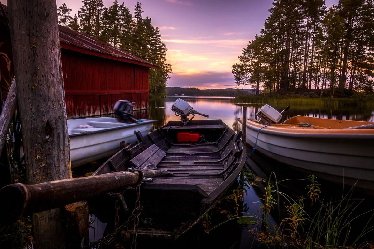 Röda sjöbodar på pelare i stilla vatten vid Gimmen.