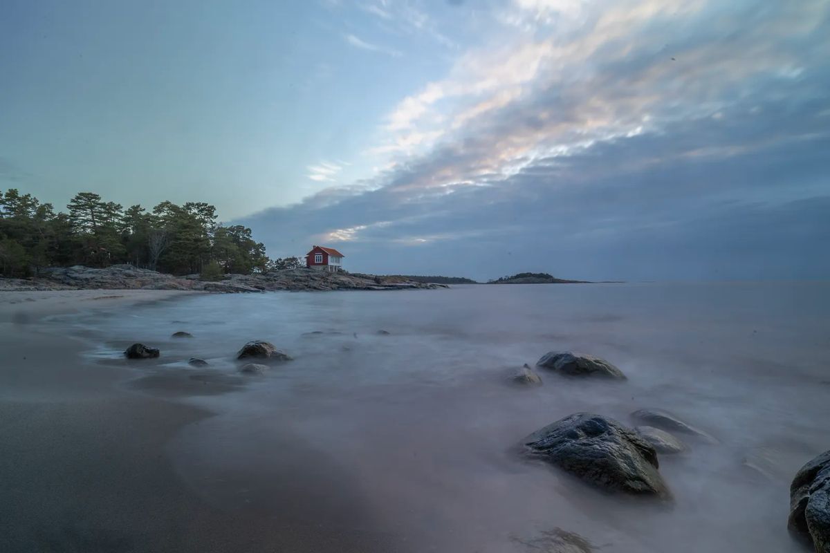 Hav, strand och rött hus
