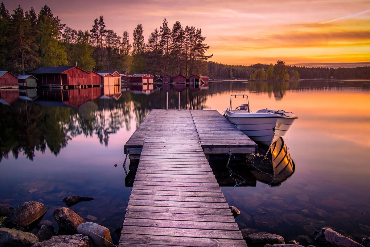 Båthus och bryggor i solnedgång vid Gimmen