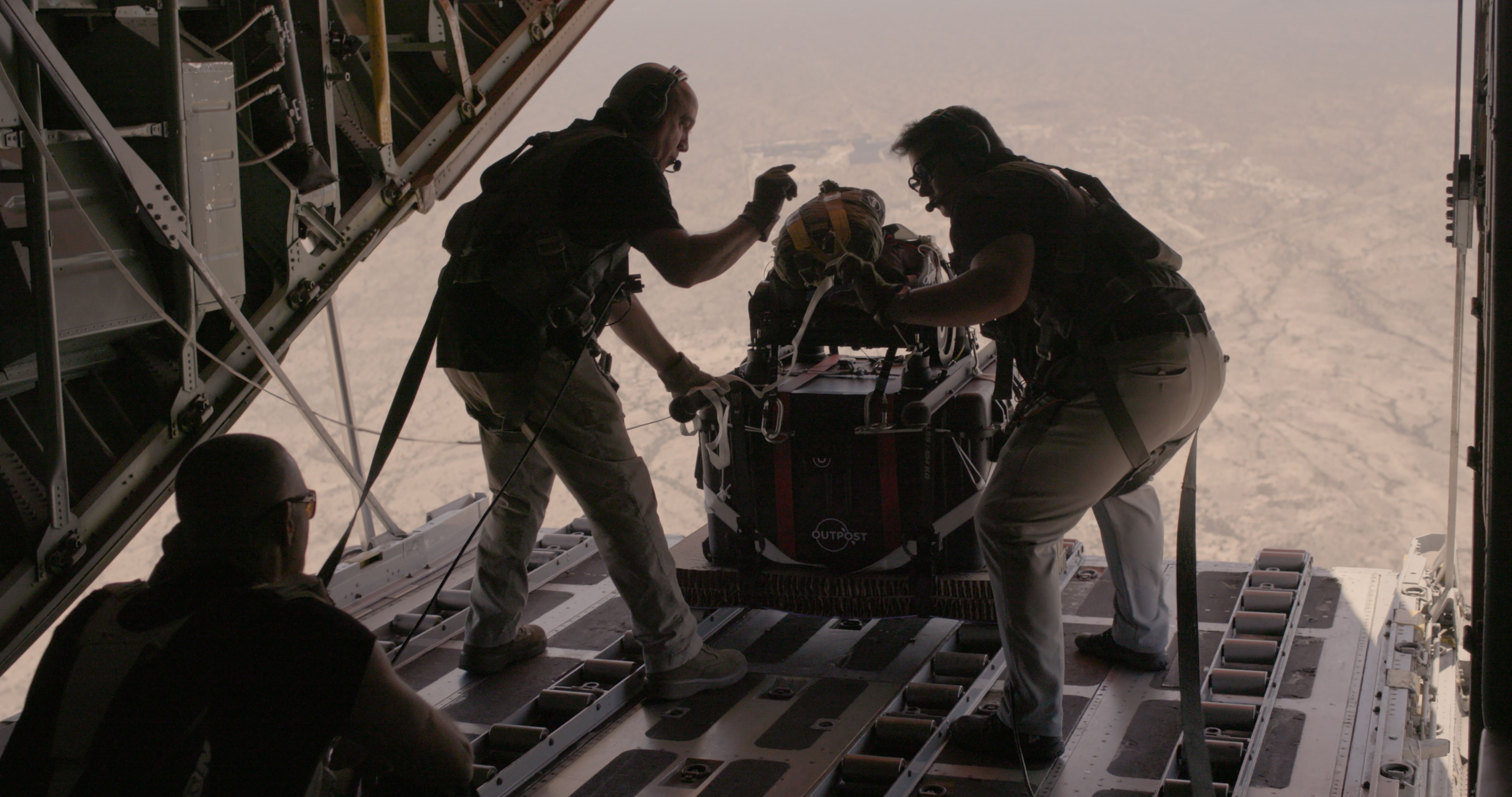 Flight crew pushing an Outpost AirDrop 200 out of a C-130 
