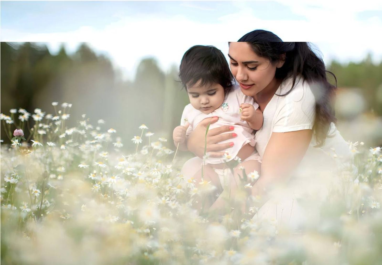 Mamma och bebis i en blommande äng