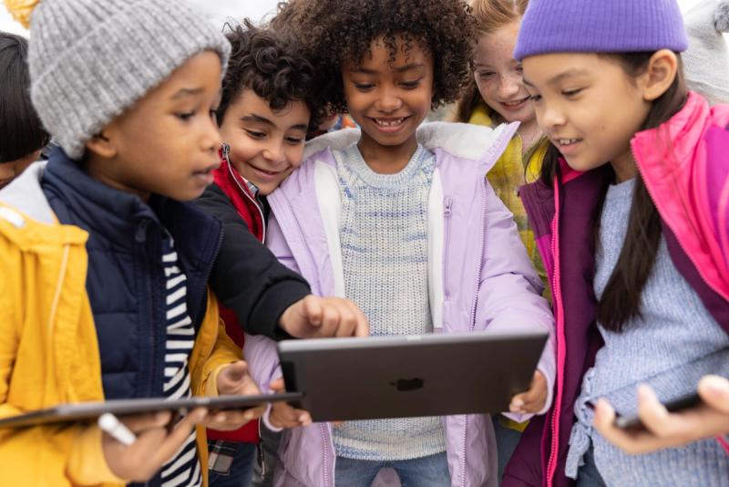 Enfant souriant autour d'un  iPad