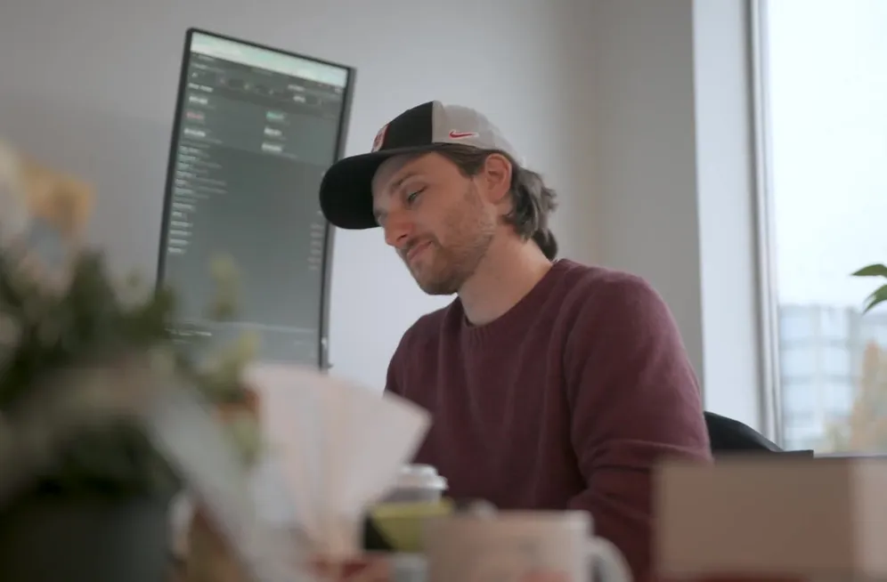 A Setsail team member smiling as he works at his laptop in the Vancouver office