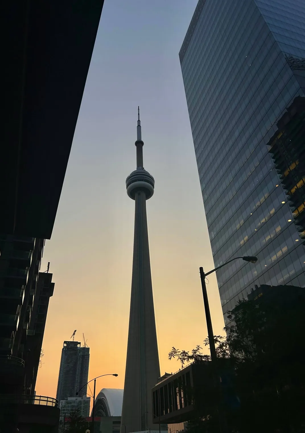 The CN Tower at dusk between downtown Toronto towers