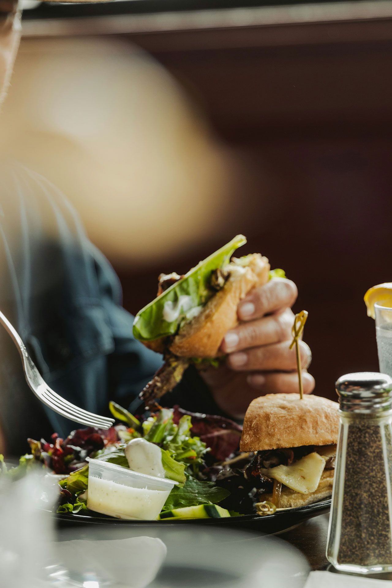 someone eating a salad and a burger