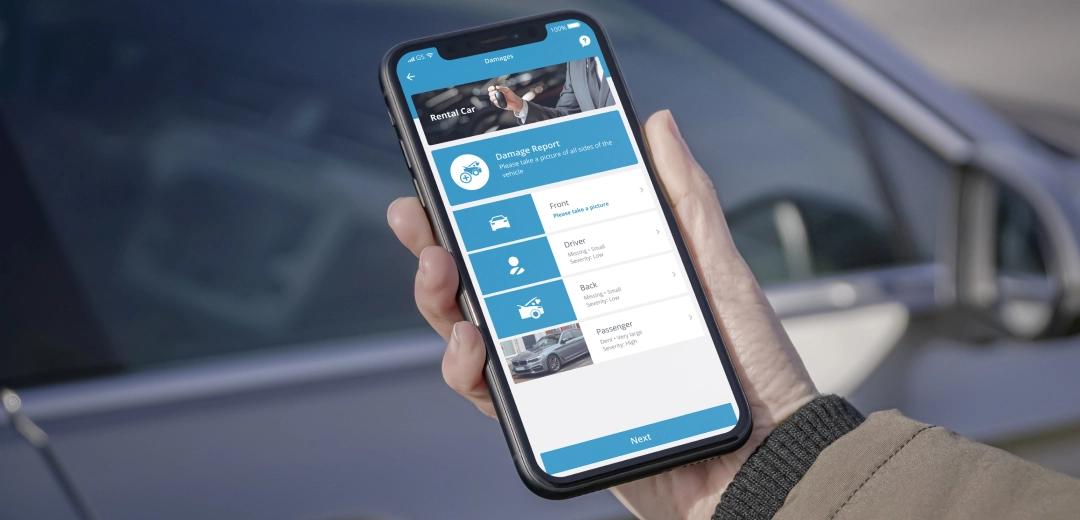 Een bestuurder met een telefoon met het scherm van de fleetster App