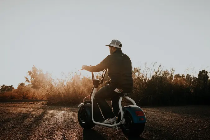 Electric scooter riding into sunset