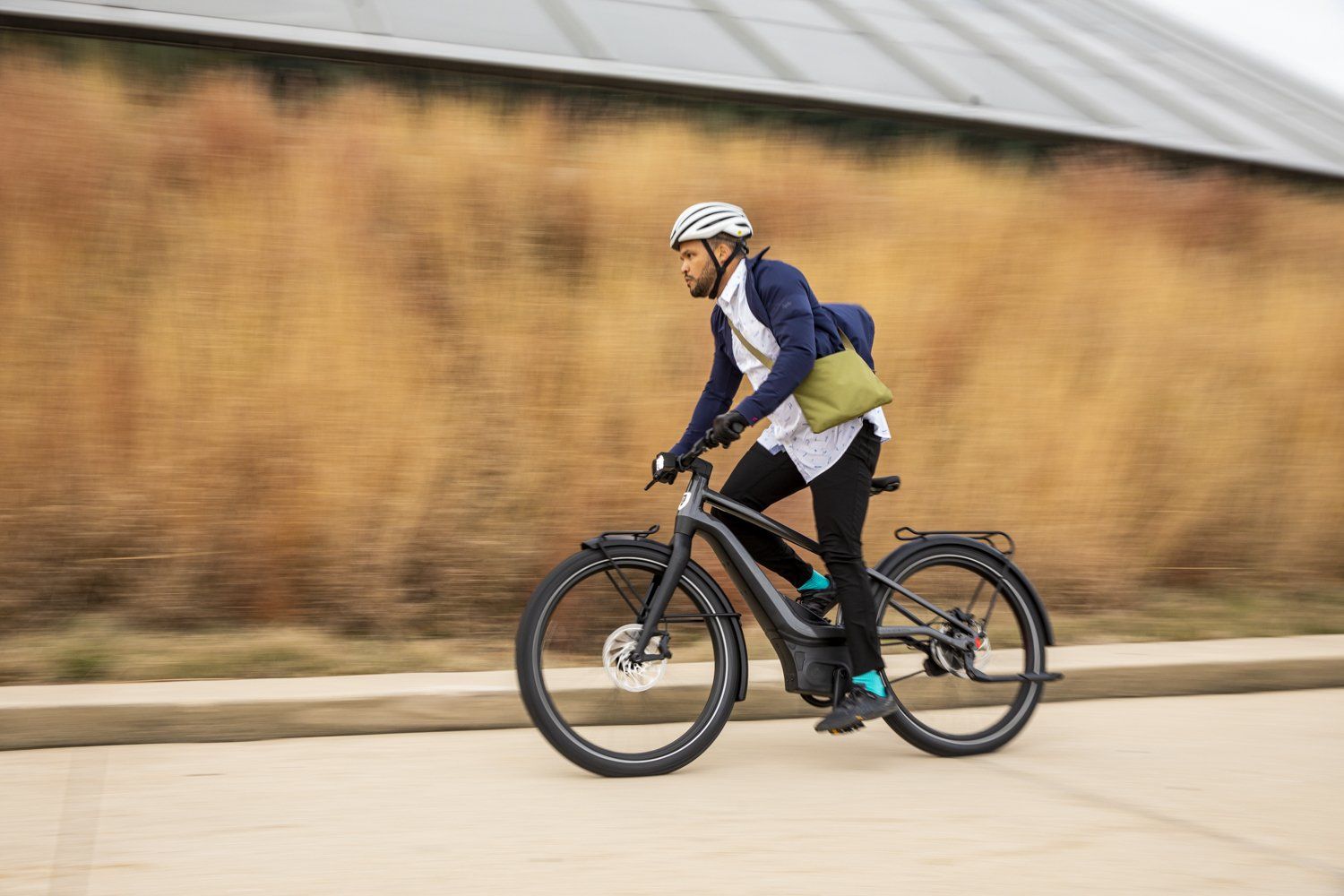 man riding on a bike with a helmet on carrying a bag on his shoulder