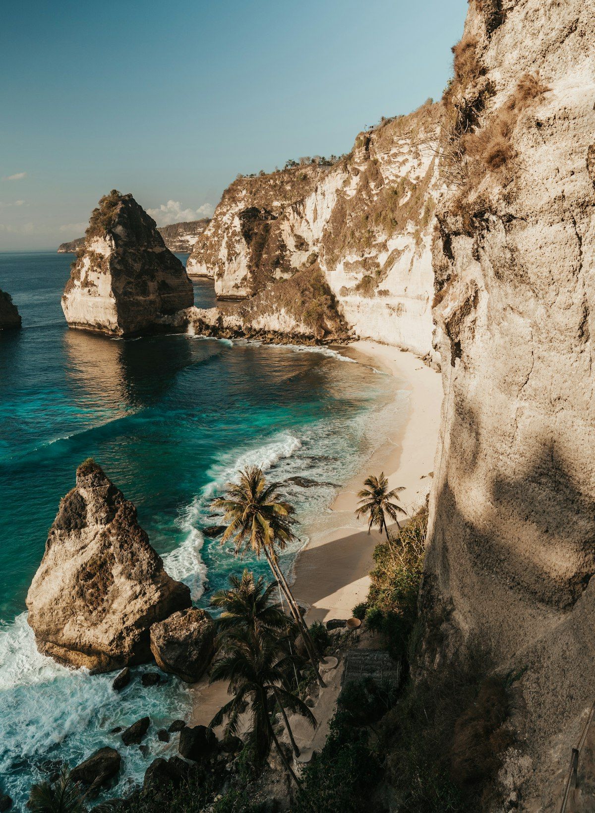 A palm-fringed Bali beach on a clear dry-season afternoon