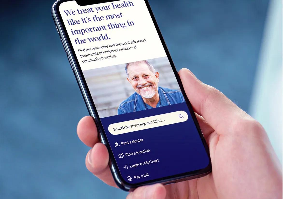 Hand holding smartphone showing website