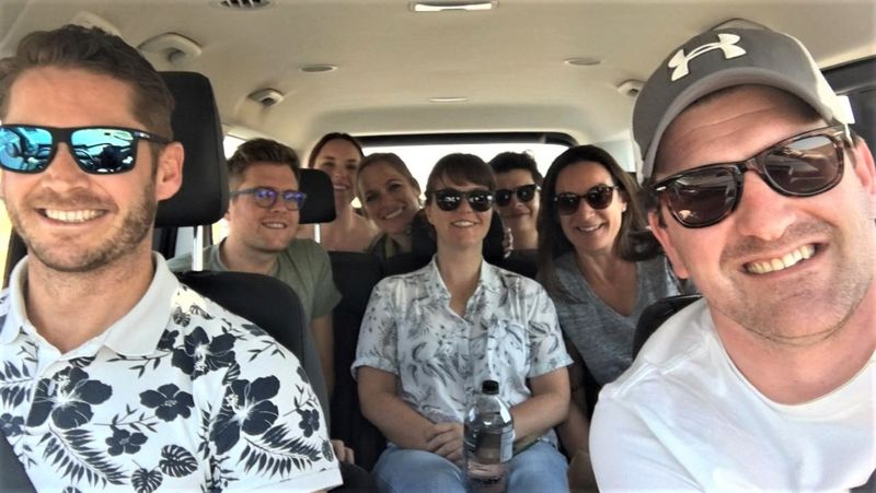 The eight members of the Rhino Crash huddled in a mini van smiling