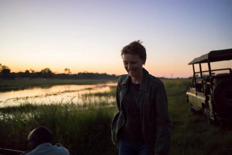 A guest enjoying the sunset beside the Okavango Delta during her safari in Botswana.
