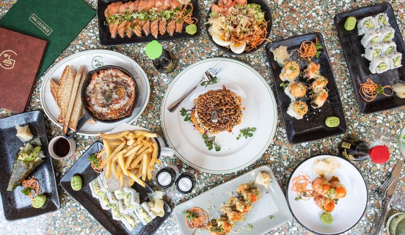 A table with beautifully-styled sushi, seafood, and other tapas