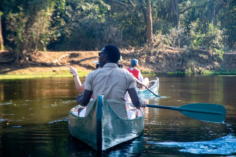 A guide leading a tour in a canoe on the Zambezi river during a Zambian safari